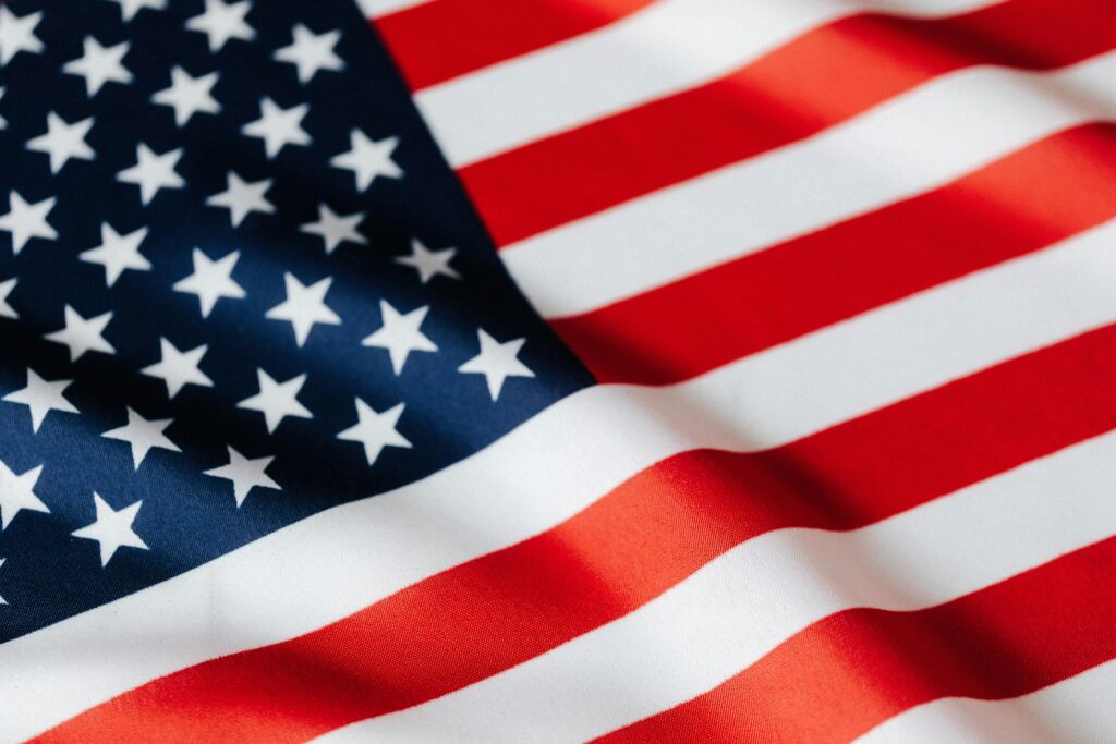 From above of closeup flattering national flag of USA with white and red stripes and stars on blue background